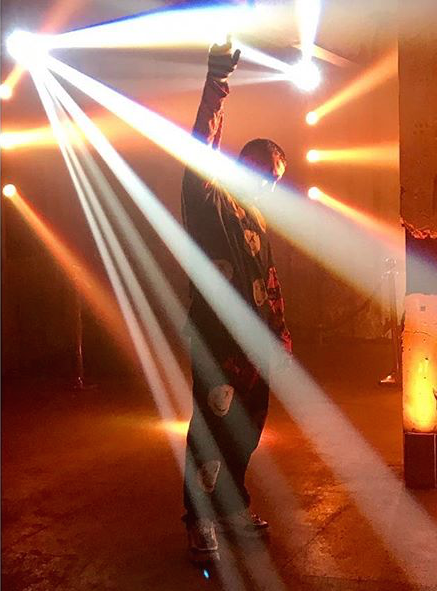  raver on empty dance floor lit by beams of light 