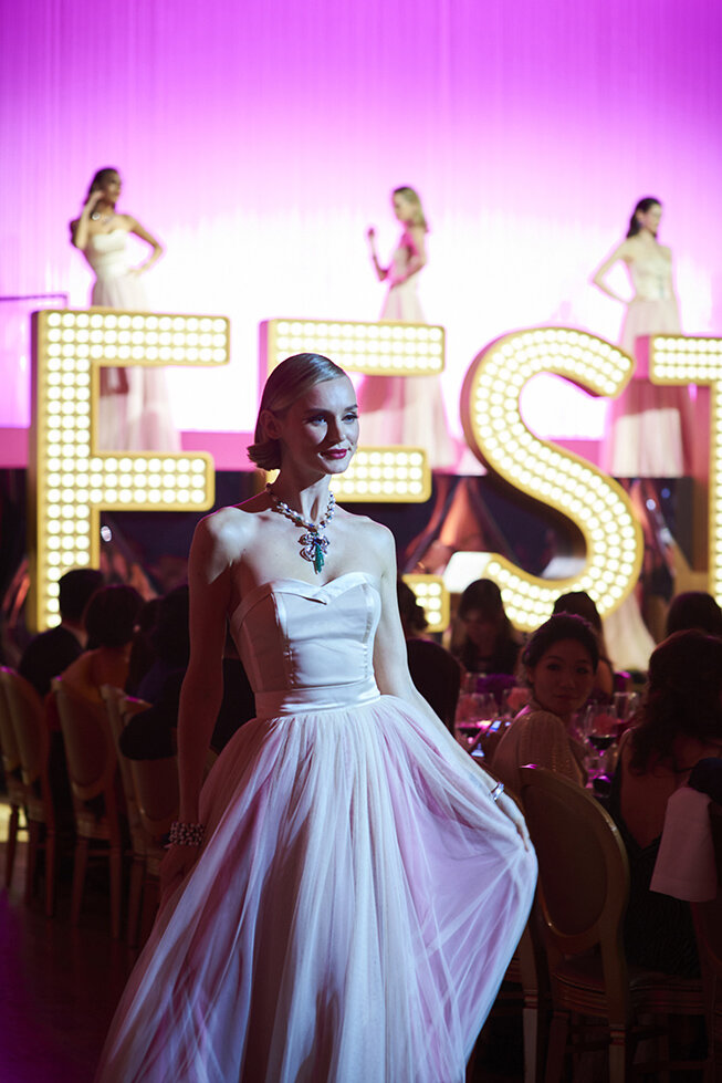 influencer wearing beautiful ball gown in front of neon lit stage for bvlgari event.jpg