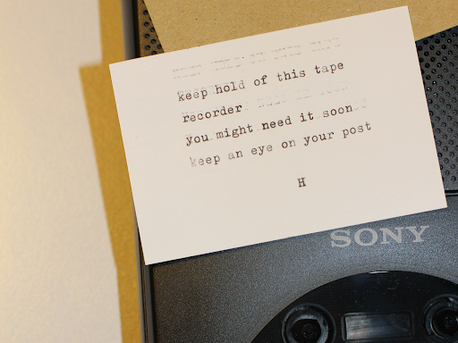  a mysterious hand typed note sits atop a Sony tape player 
