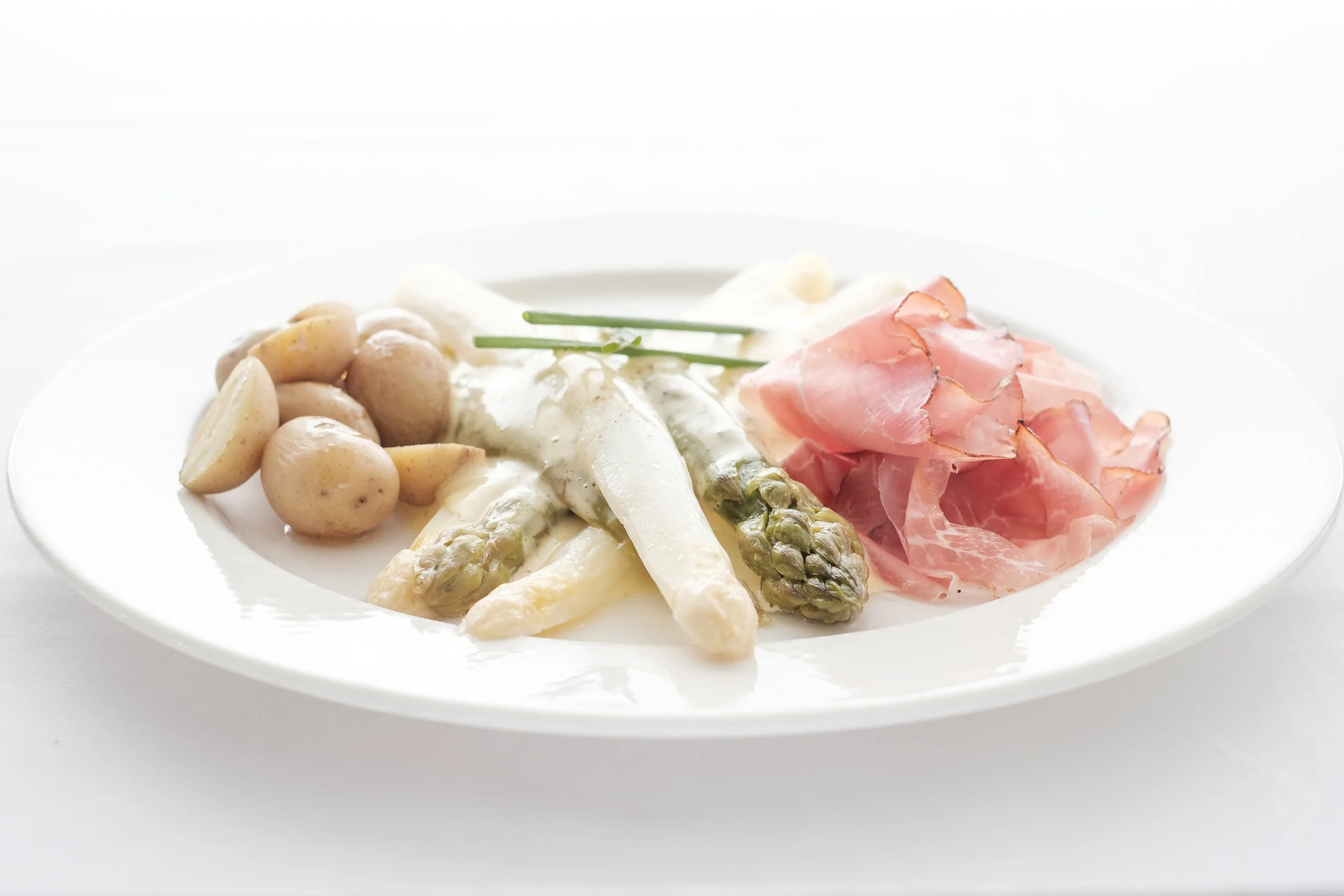 Spargeln gemischt mit Rohschinken und Bratkartoffeln an Hollandaisesauce