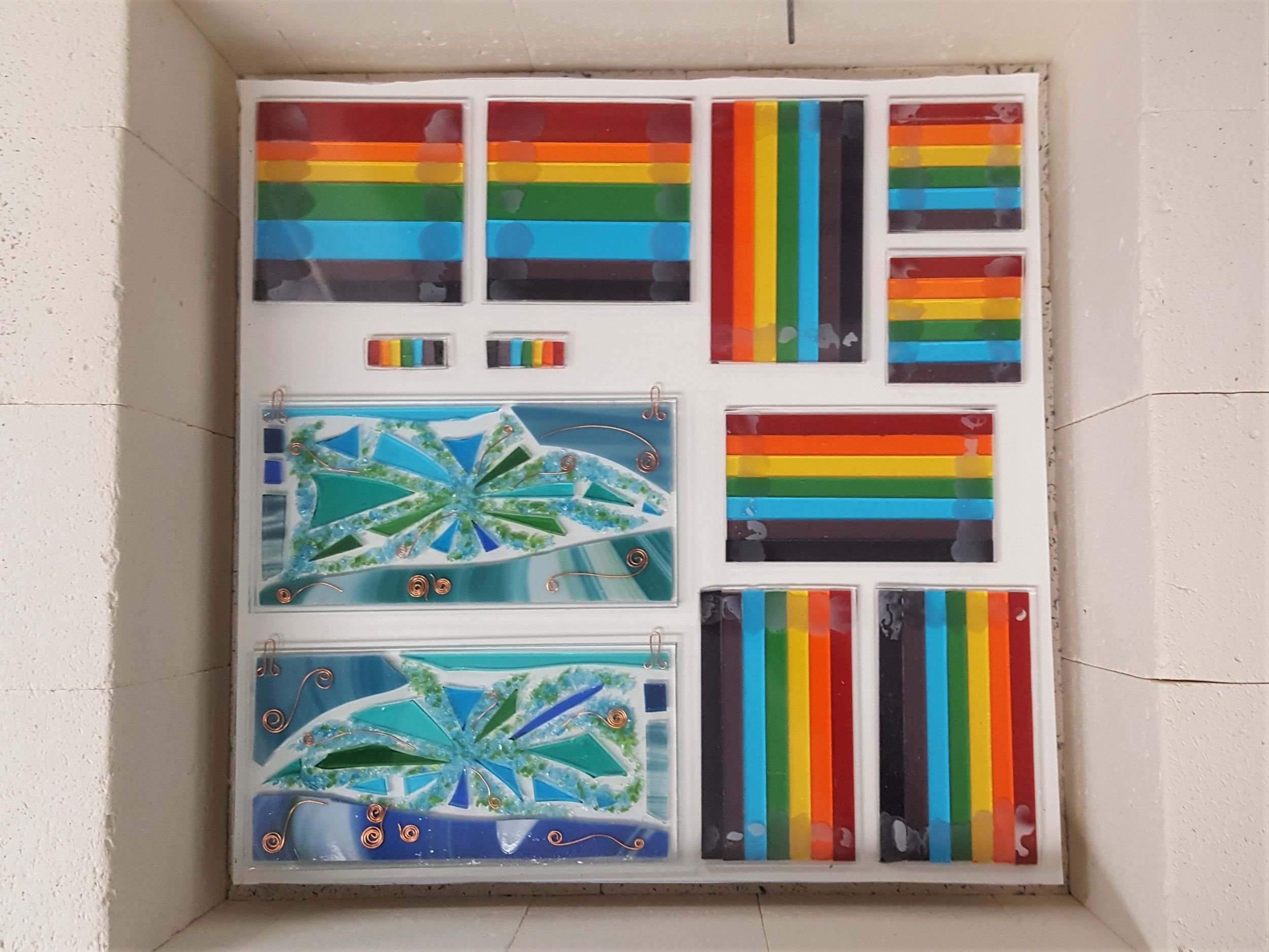 Fused glass coasters and wall panels waiting to be fired in a kiln by Eva Glass Design