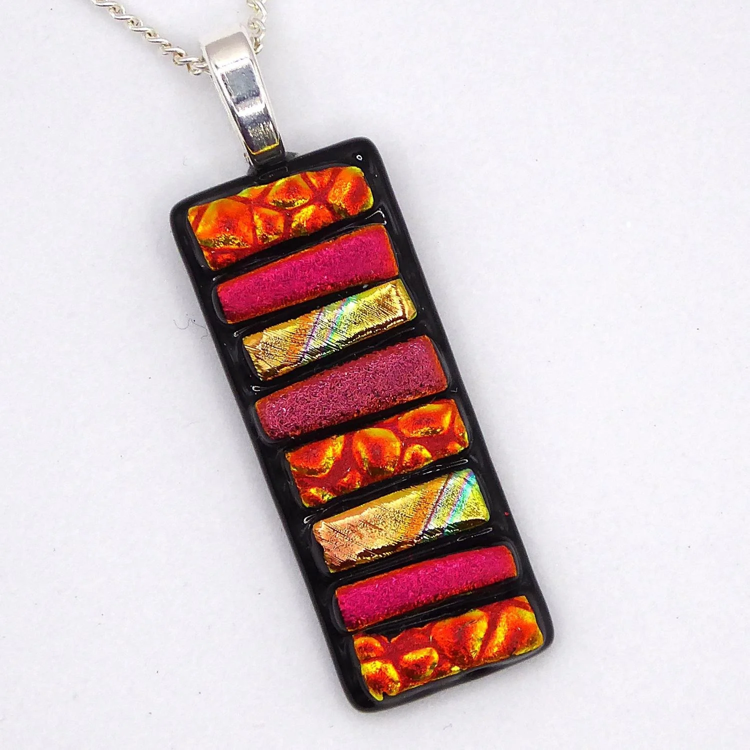  Fused glass necklace with strips of gold and red dichroic glass fused onto black glass 