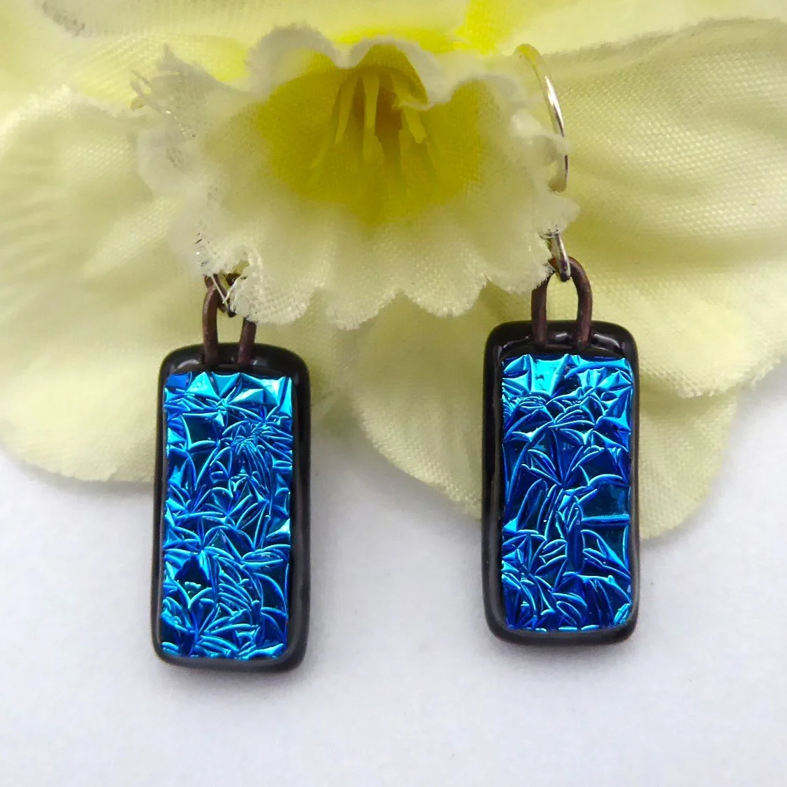  Fused glass drop earrings with a textured blue glass on a black background 