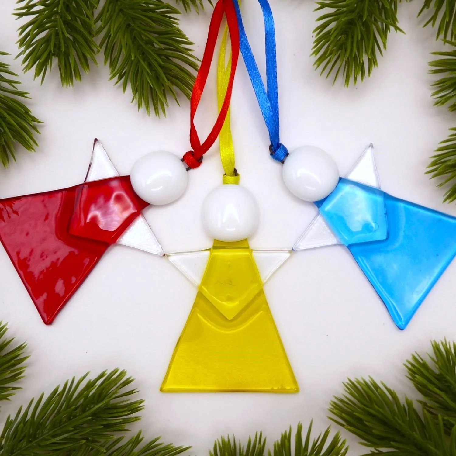  Three angel Christmas decorations made from coloured glass in red, yellow and blue 