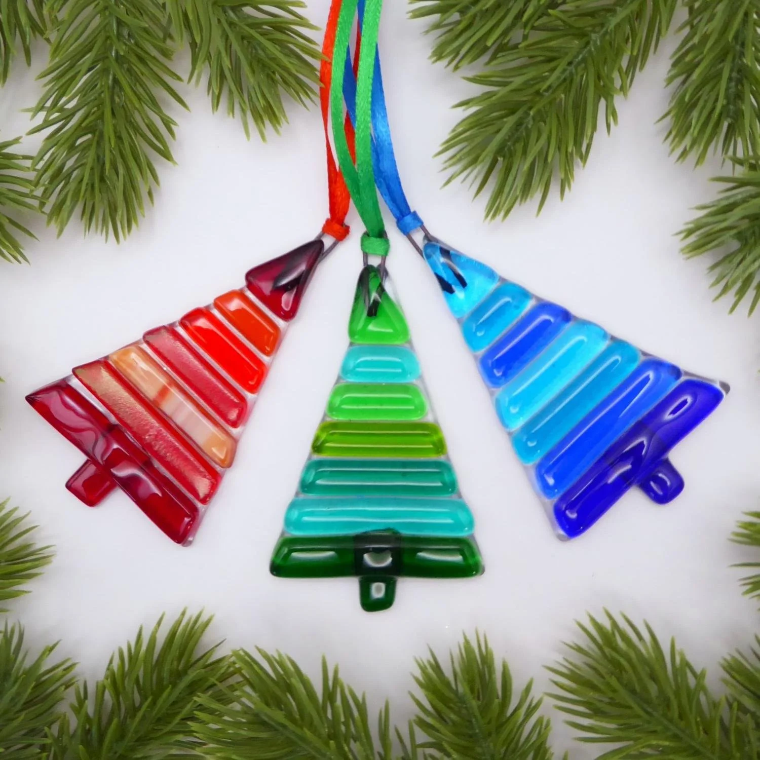  Three fused glass Christmas trees with colourful stripes in shades of red, green or blue 