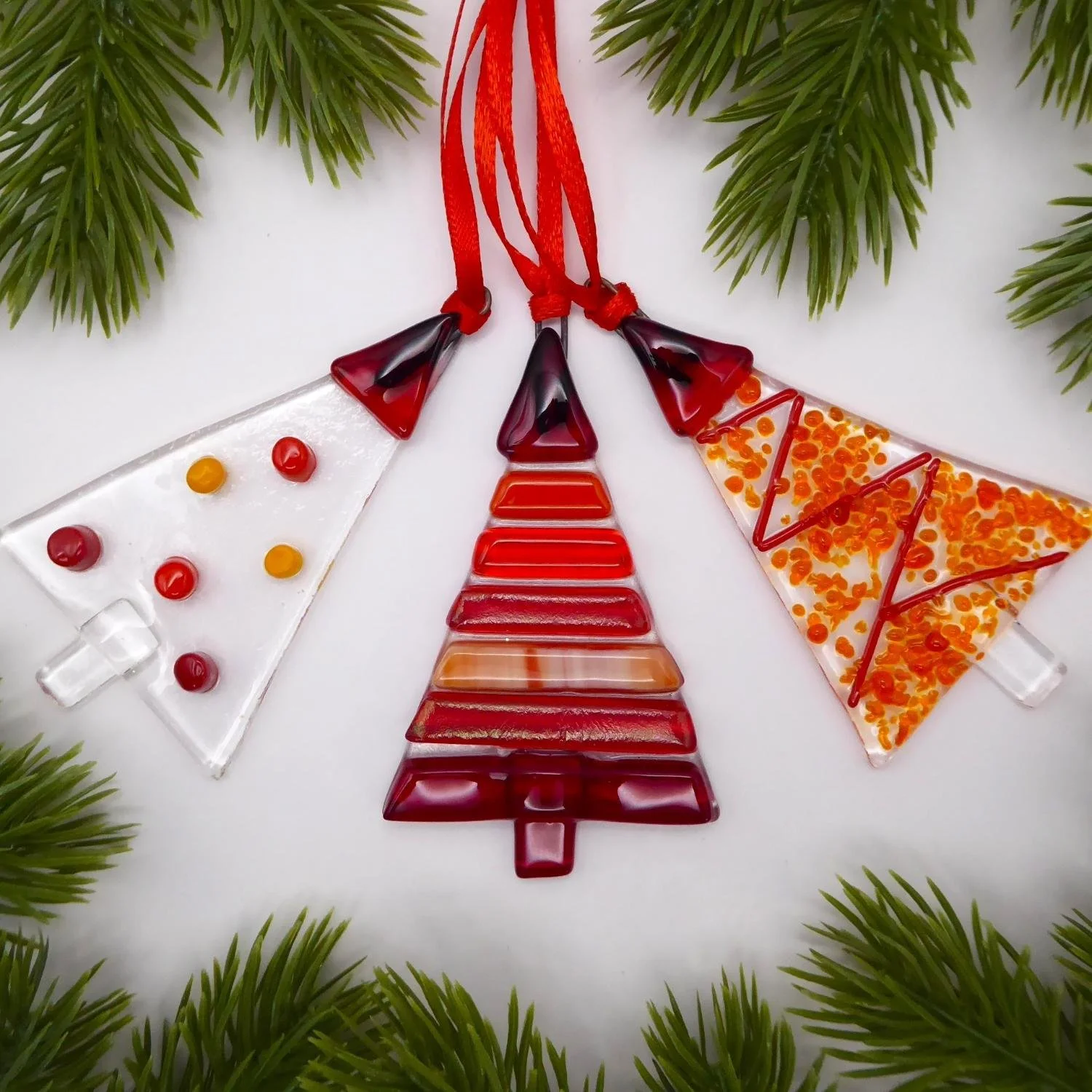  Set of three fused glass Christmas trees with red designs 