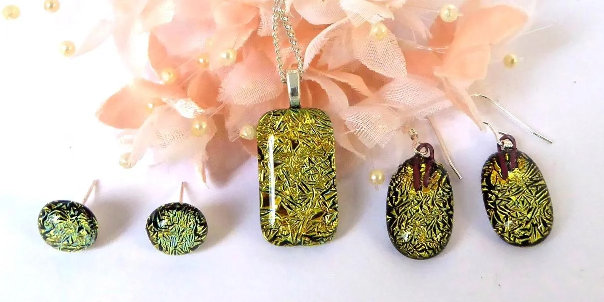 Beautiful gold dichroic glass jewellery gift set including pendant, drop earrings and stud earrings.