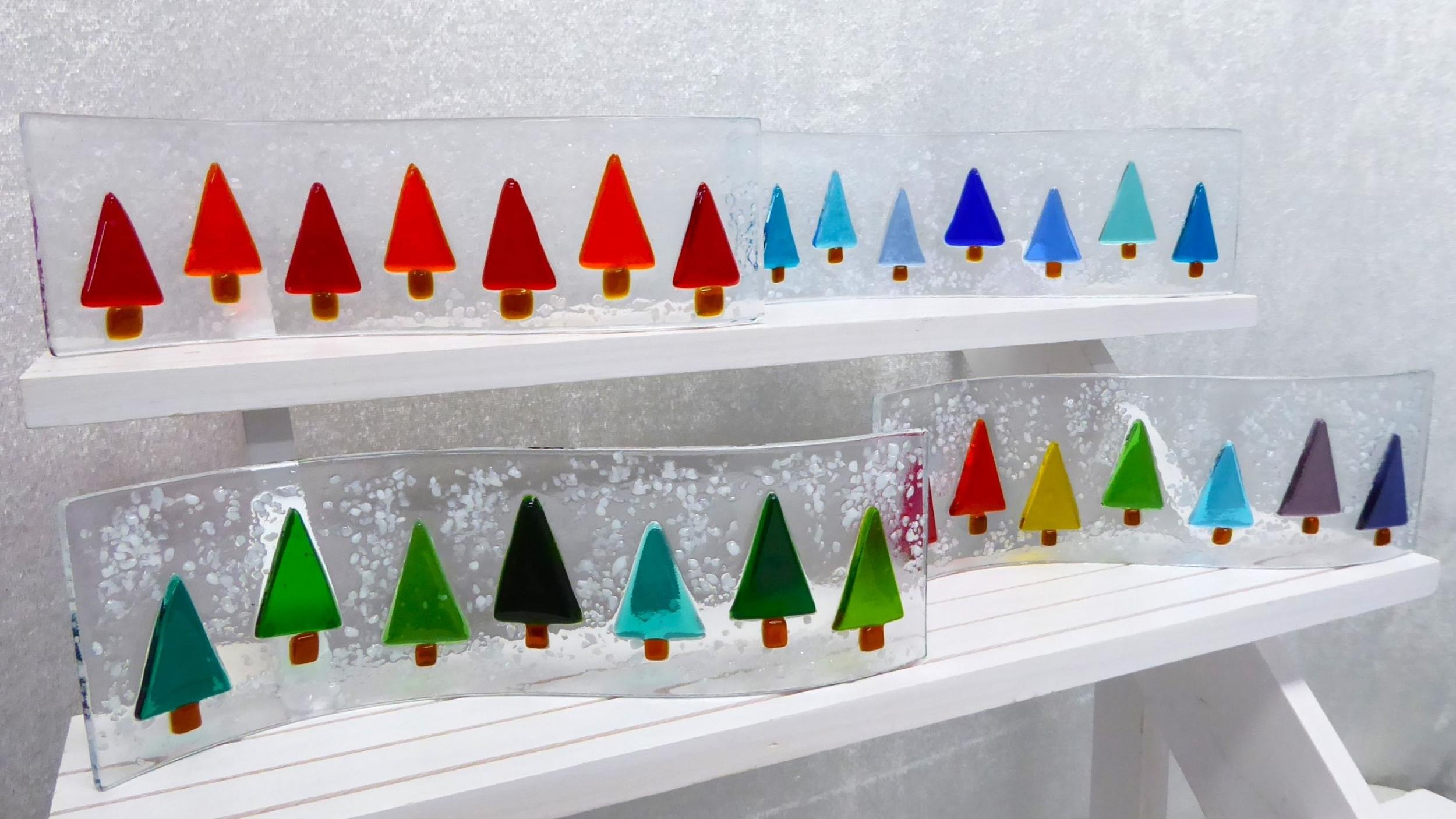 Freestanding fused glass waves featuring colourful trees in a snowy woodland