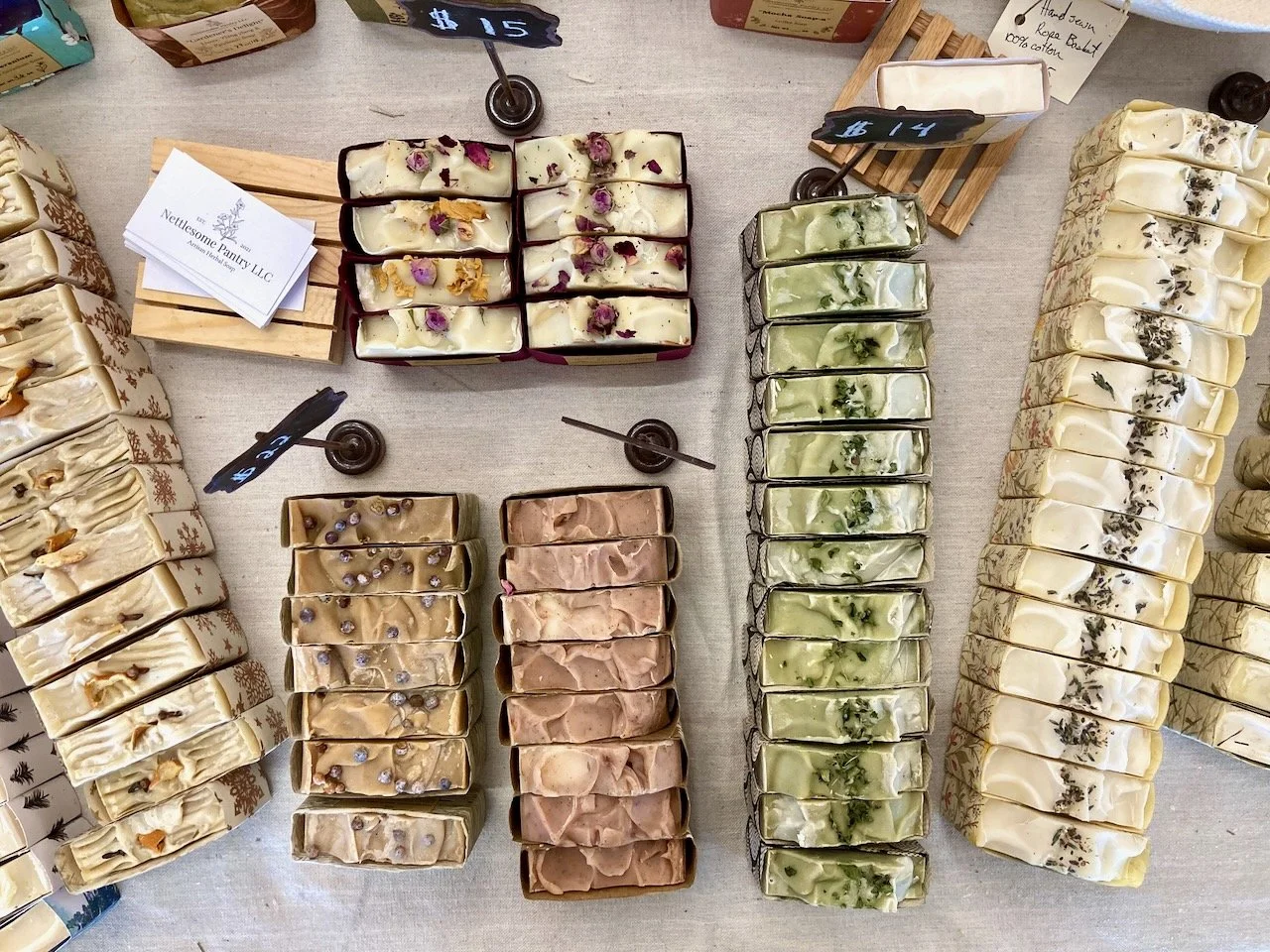 bar soap lined up on a table with price signs