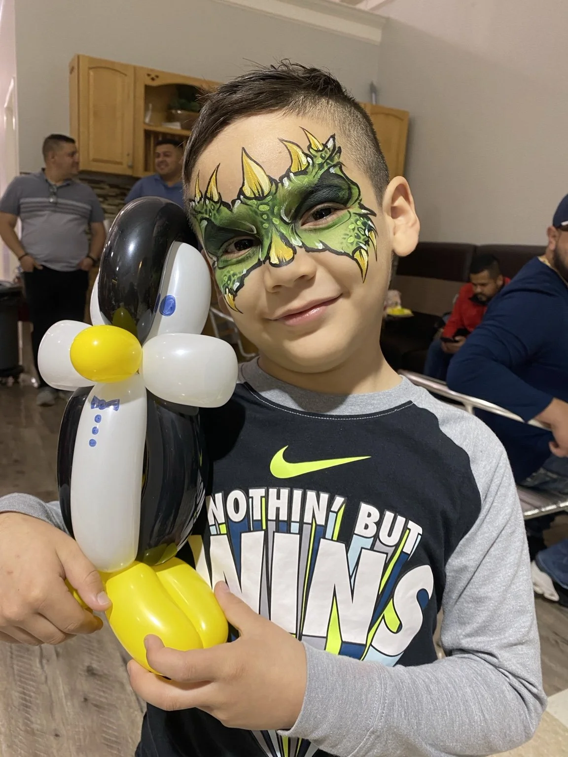 Child holding a penguin balloon at a party