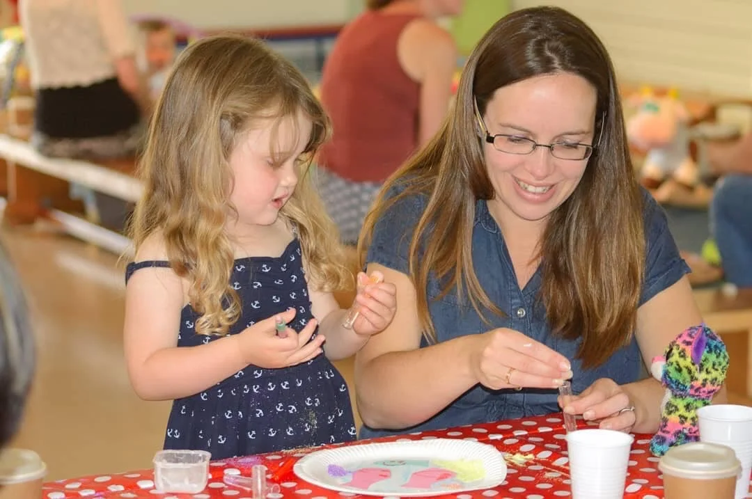 Little girl does a craft with a children worker at Love Caerphilly
