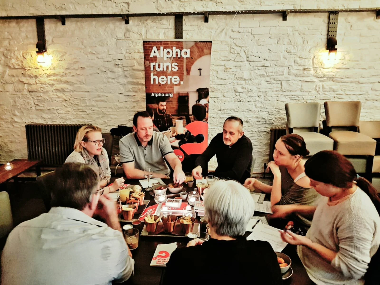 Group of people explore Christianity around a table
