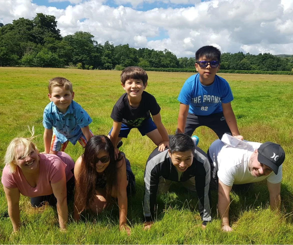 Children make a human pyramid in a field in Caerphilly