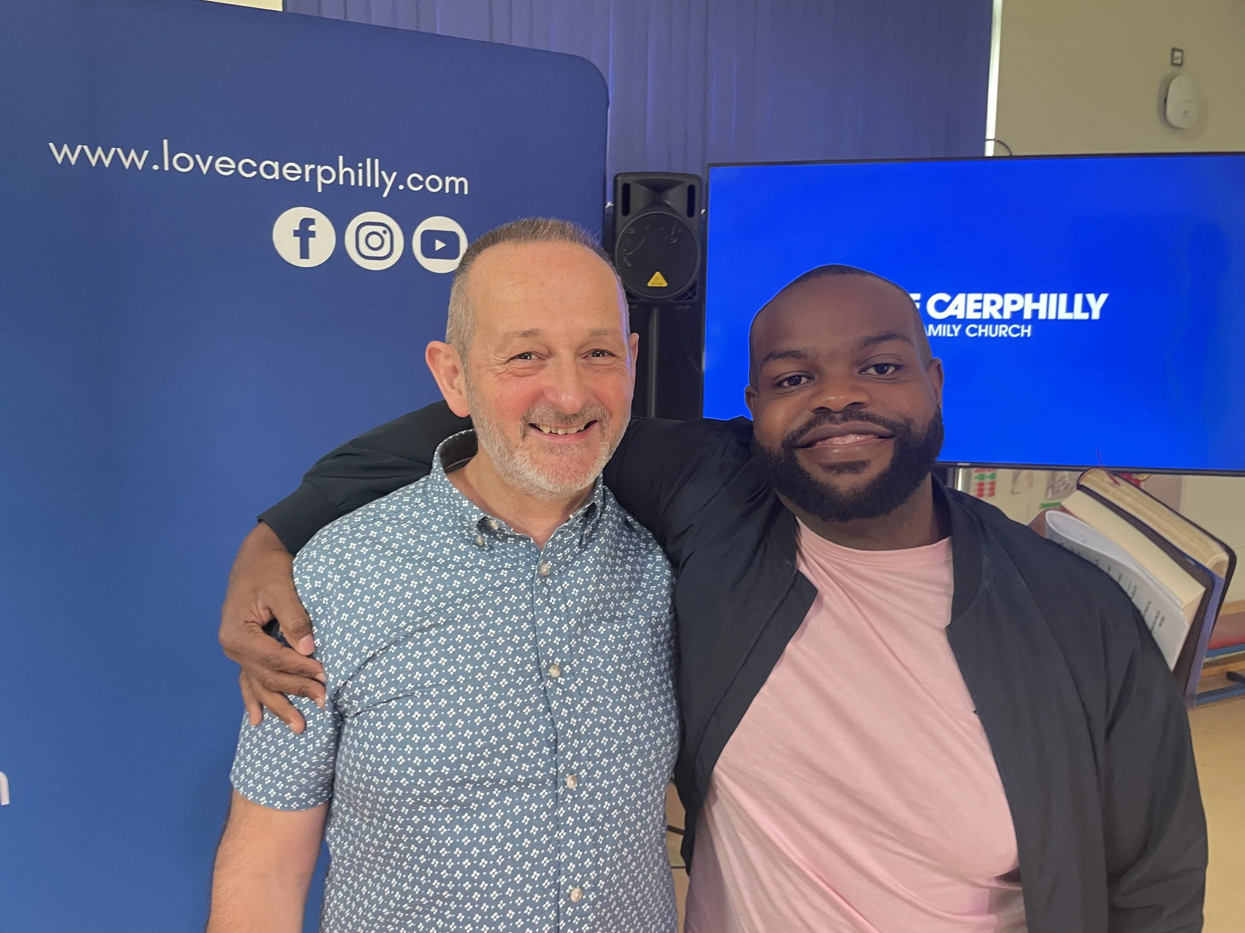 Two men smiling with a blue background at Love Caerphilly Family Church