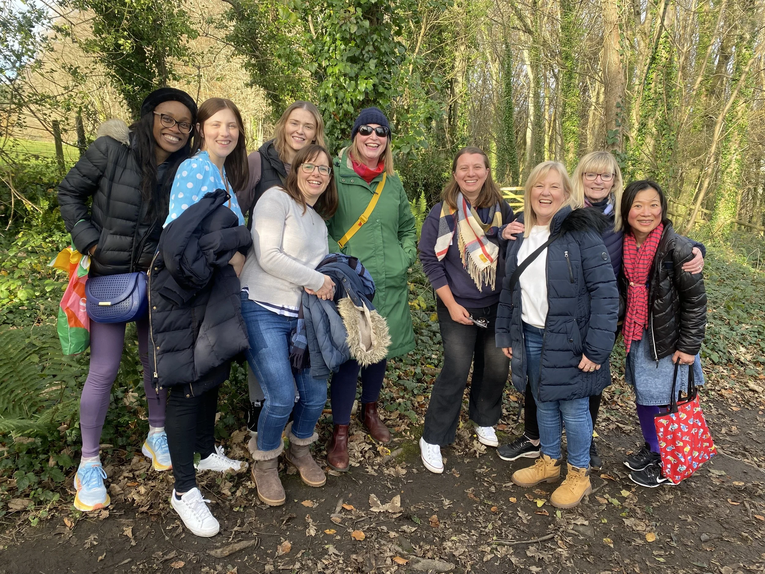 A community group of women at Love Caerphilly Church pause for a photo on a woodland walk