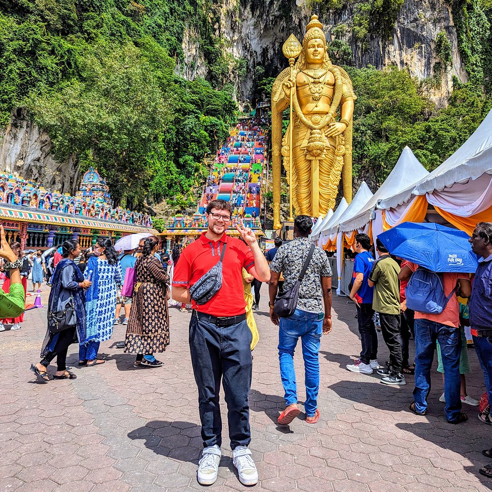  Posing with Lord Murugan at the Batu Caves, just outside Kuala Lumpur, Selangor, Malaysia (2024). 