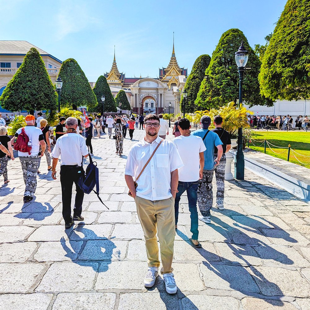  Posing at the entrance to the Grand Palace grounds, Bangkok, Thailand (2024). 