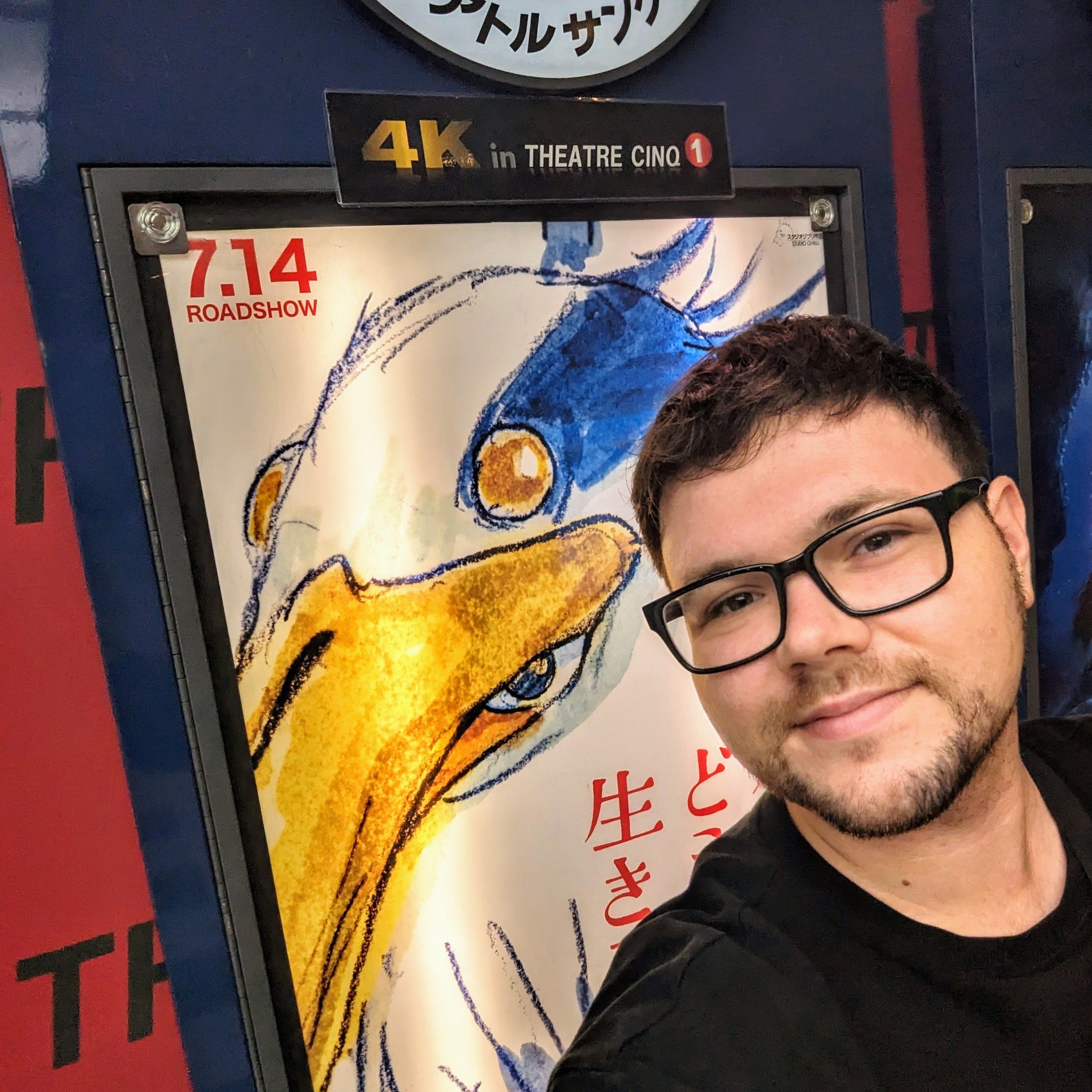 Danny posing with the promotional poster for Studio Ghibli’s How Do You Live?