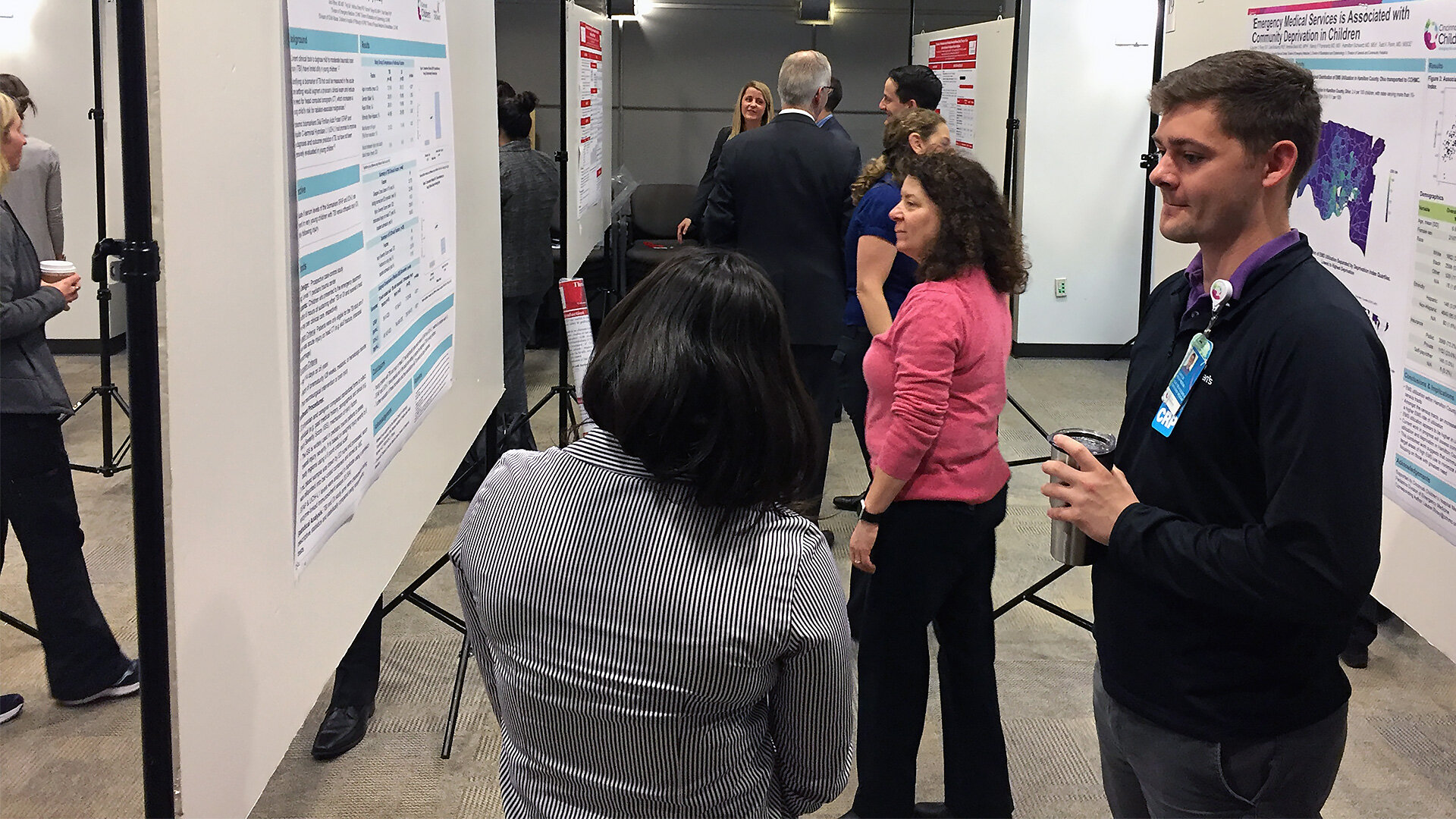  Symposium attendees viewing an academic poster.  