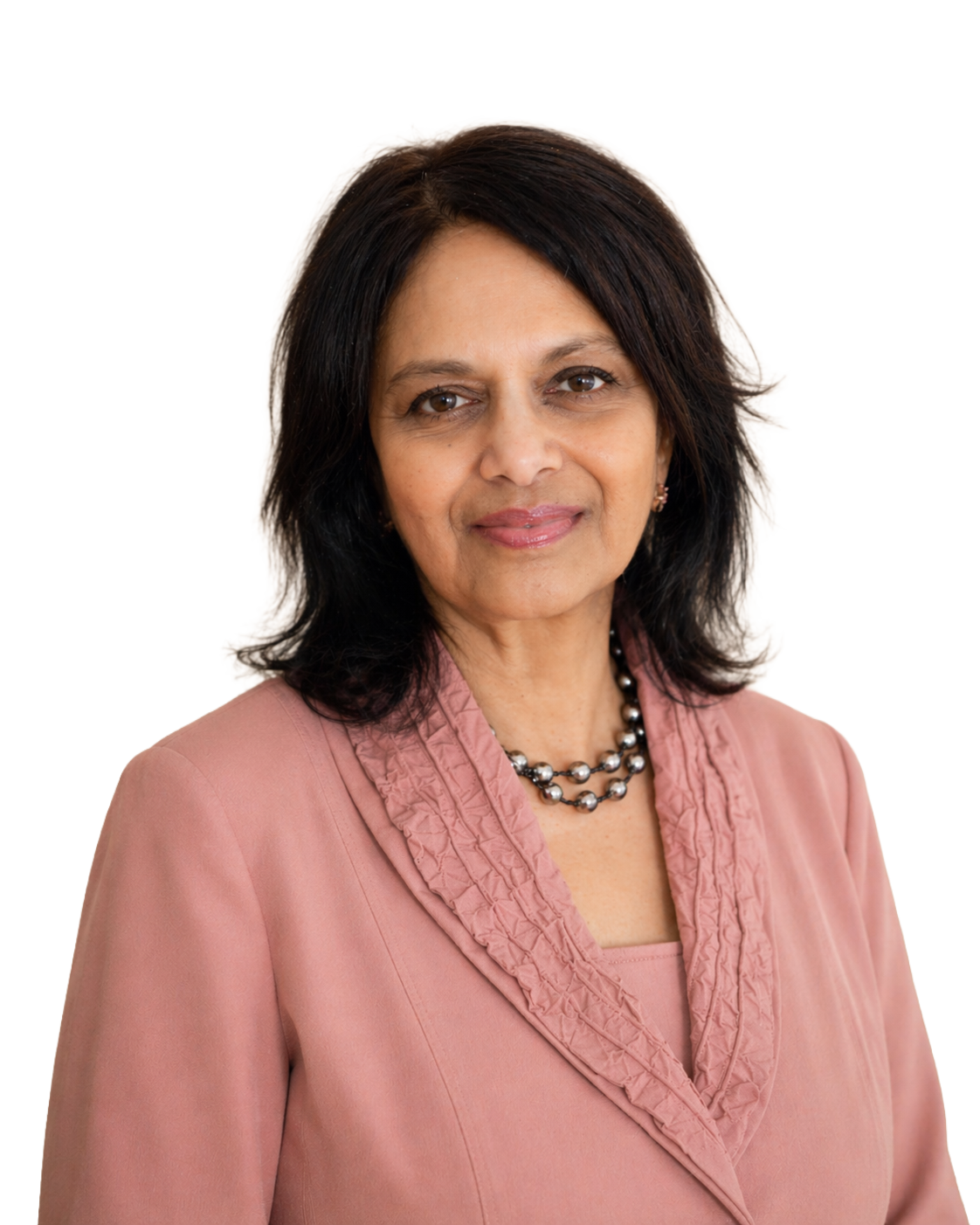 A middle-aged woman with shoulder-length black hair, wearing a pink blazer with a ruffled collar and a double strand of pearls, smiling softly at the camera.