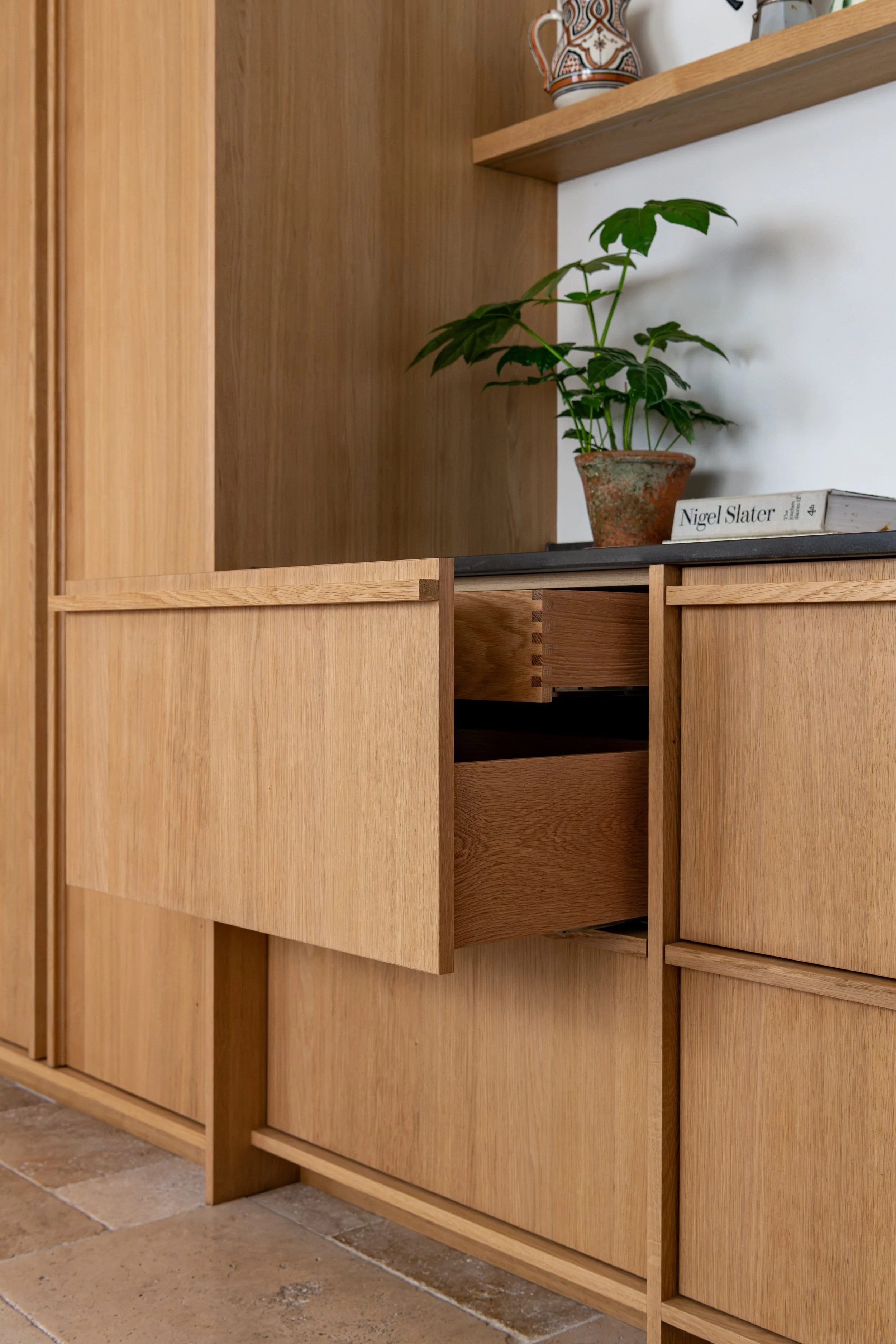 Bespoke oak pantry cabinet with drawers open to reveal internal storage.