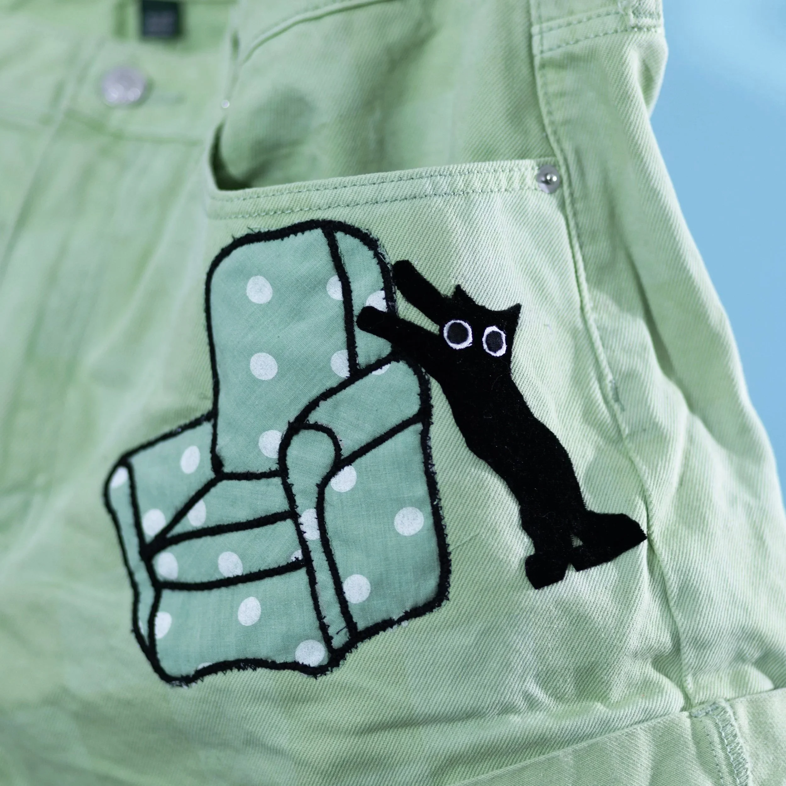 green shorts sofa chair green black cat.jpg