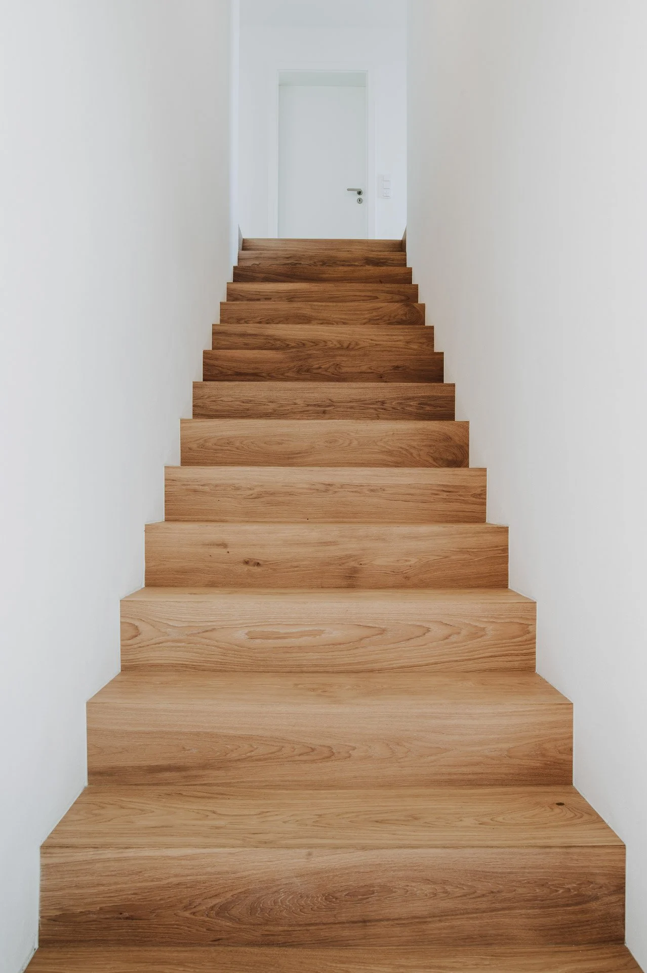 Holztreppe in weißem treppenaufgang