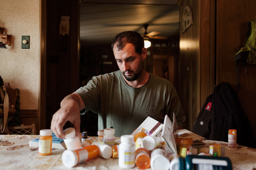 FARMER_VETERAN - U.S. Army veteran Alex Sutton sorts through the many prescription medications that he takes on a daily basis [websize].jpg