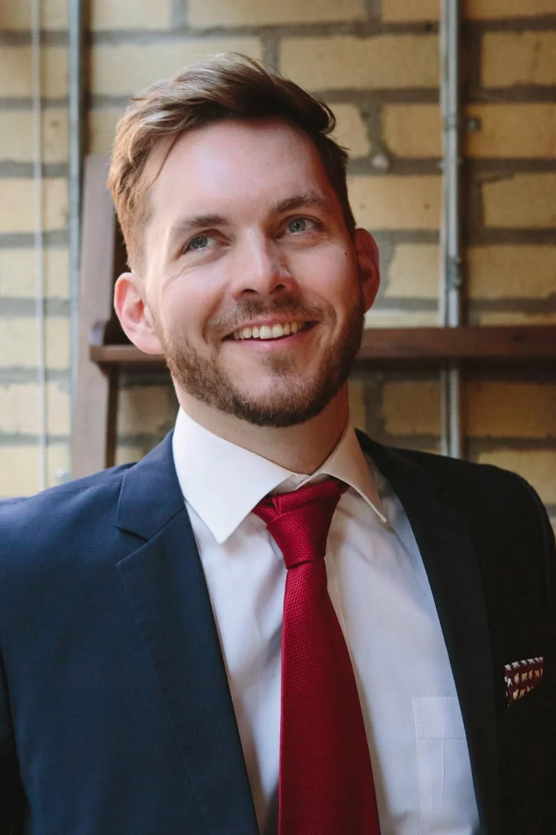 Photo of lawyer Marcus McCann near a window, brick background. Photo by Jocelyn Reynolds