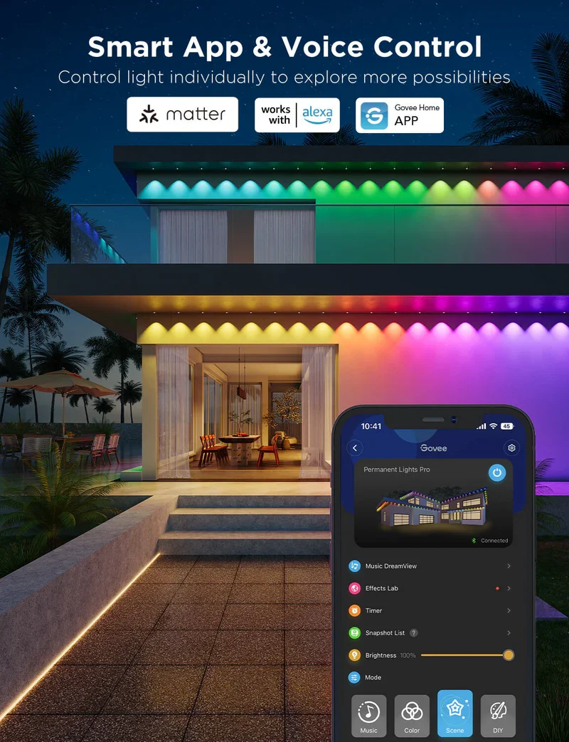 A modern house illuminated with multicolored LED lights on the exterior during nighttime, with a smartphone displaying a smart lighting app that controls the house's lighting system.