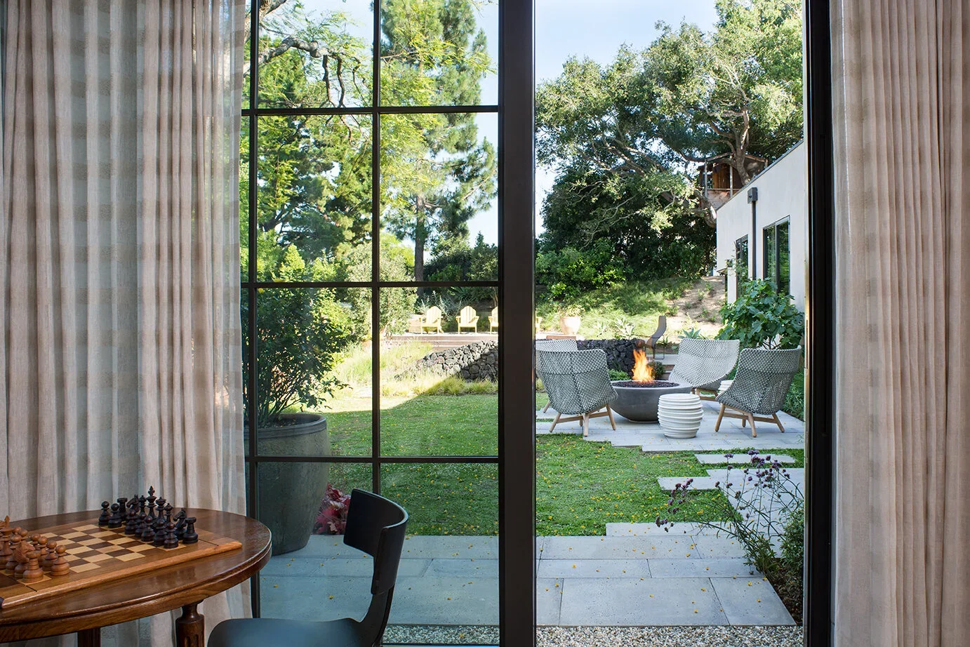 Steel-French-Doors-Chess-Table-Rear-Yard-Patio-Perfitt-Richards.webp