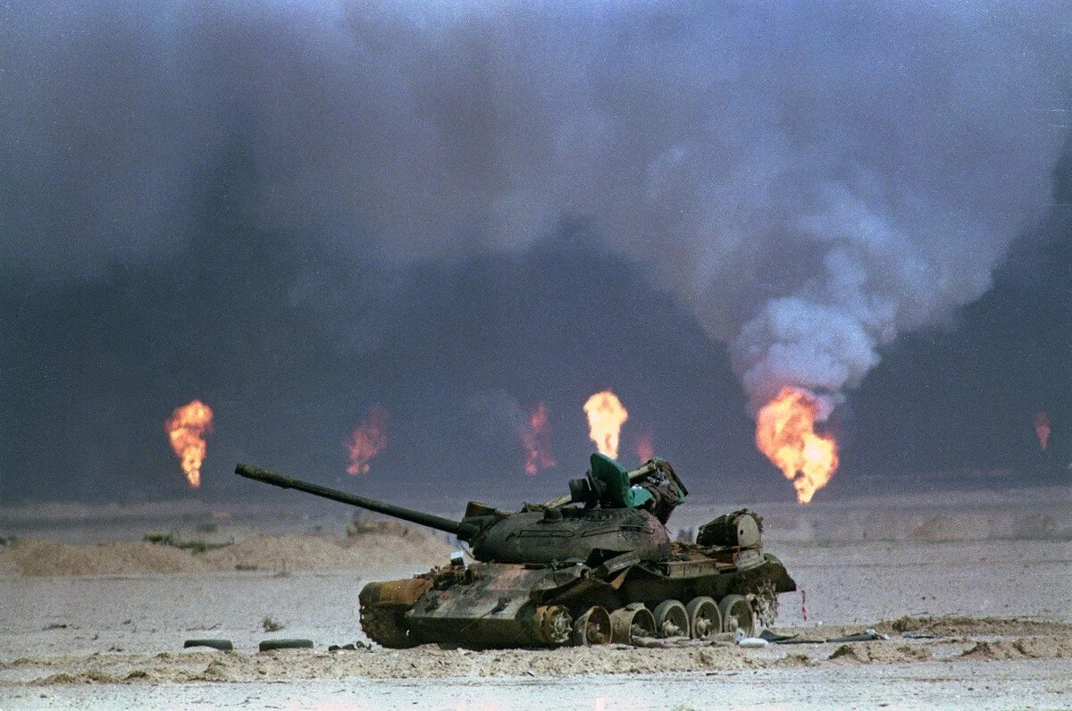 A destroyed Iraqi tank rests near a series of oil-well fires during the Gulf War, on March 9, 1991, in northern Kuwait. David Longstreath / AP