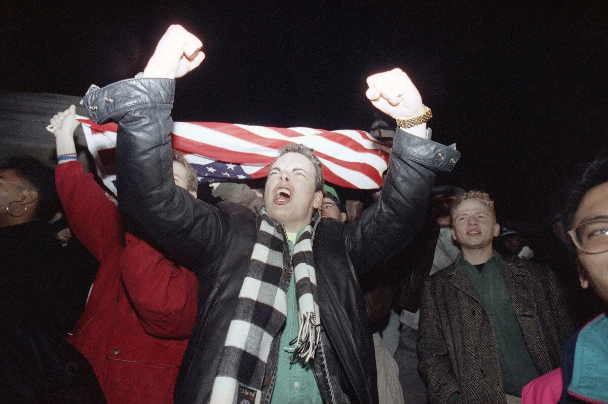 Boston University freshman Christopher Cooley raises his fists before a U.S. flag in support of news that the U.S. forces had started military actions against Iraq, during a demonstration at the Statehouse in Boston on January 17, 1991. Gayle Shomer…