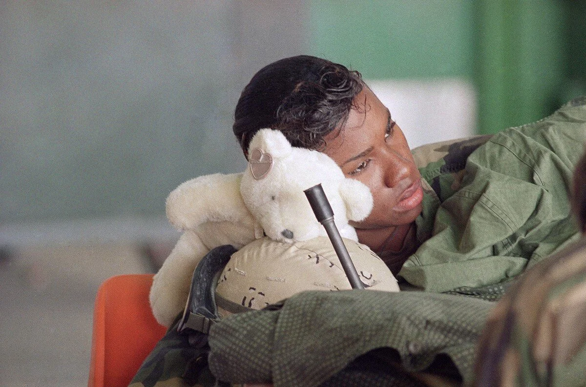 Sergeant Rachel Forehand, from Brooklyn, New York, rests her head on a stuffed bear as the U.N. deadline for Iraq to withdraw from Kuwait passed in Saudi Arabia on January 16, 1991. Forehand is a nurse with 28th Combat Support Hospital, stationed at…