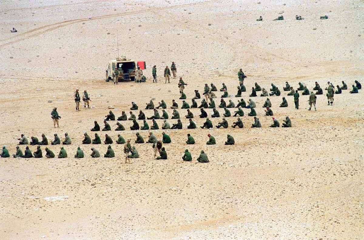 Somewhere in Iraqi desert, U.S soldiers guard captured Iraqi prisoners of war on February 25, 1991. Mike Nelson / AFP / Getty