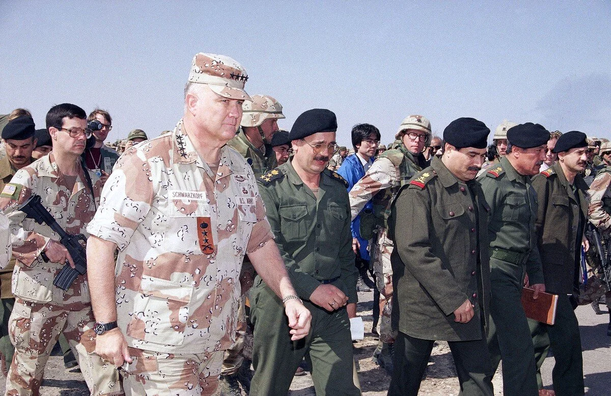 U.S. General H. Norman Schwarzkopf, left, escorts Iraqi Lt. General Sultan Hashim Ahmad, third from left, with other Iraqi military leaders to a tent prior to the start of a meeting to set the terms for a permanent ceasefire. The meeting took place …
