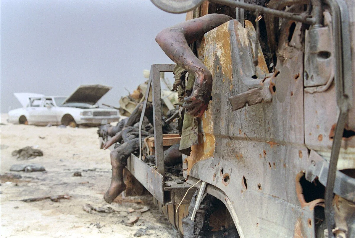 The bodies of dead Iraqi soldiers hang from a truck abandoned by fleeing Iraqi army on the road in North-Eastern Kuwait, leading to Iraq, on March 11, 1991. Pascal Guyot / AFP / Getty