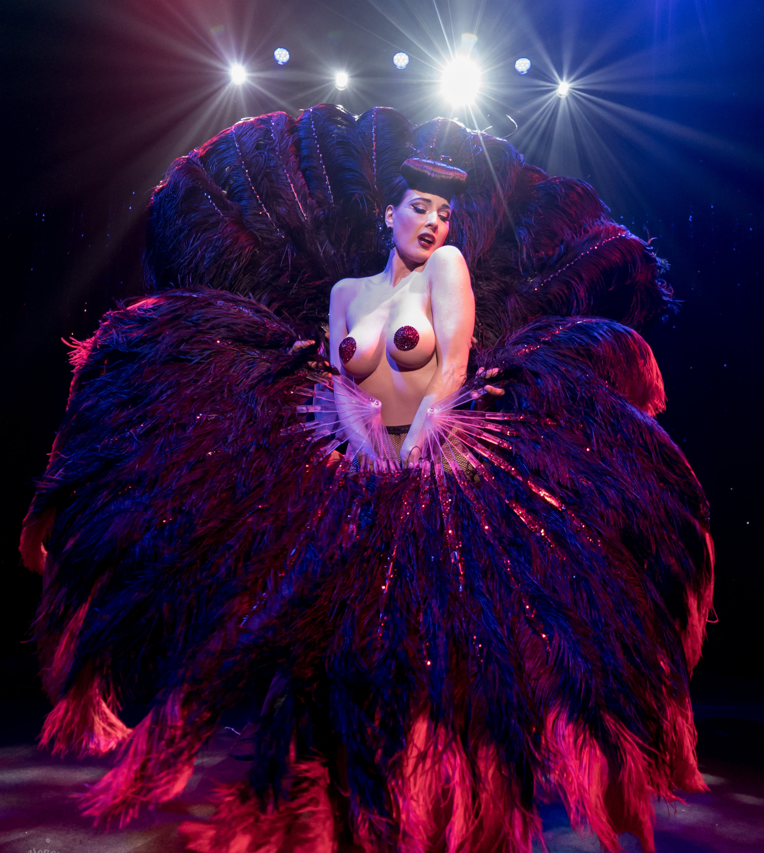 Dita hypnotizes the audience, surrounded by decadent plumes of ostrich feathers.