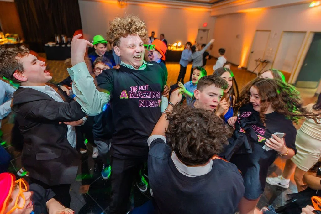 Children dancing and having fun at a party with colorful lights and decorations.