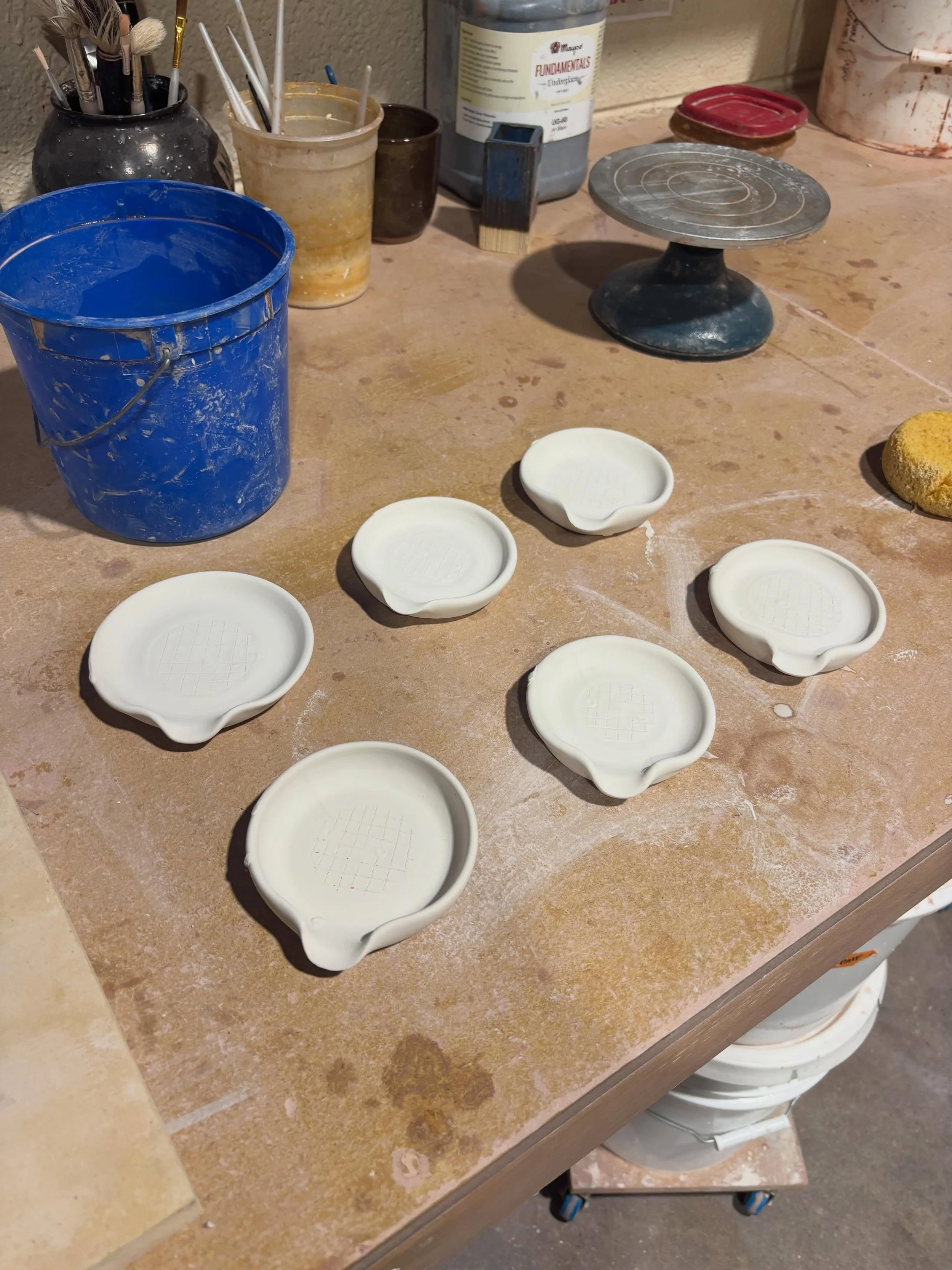 Spoon rests are glazed and ready to go into the kiln! I had a brain fart and didn&rsquo;t put the yellow bottoms on them, but they&rsquo;re still cute. These are meant for silverware rather than kitchen utensils, so they&rsquo;re a little on the smal