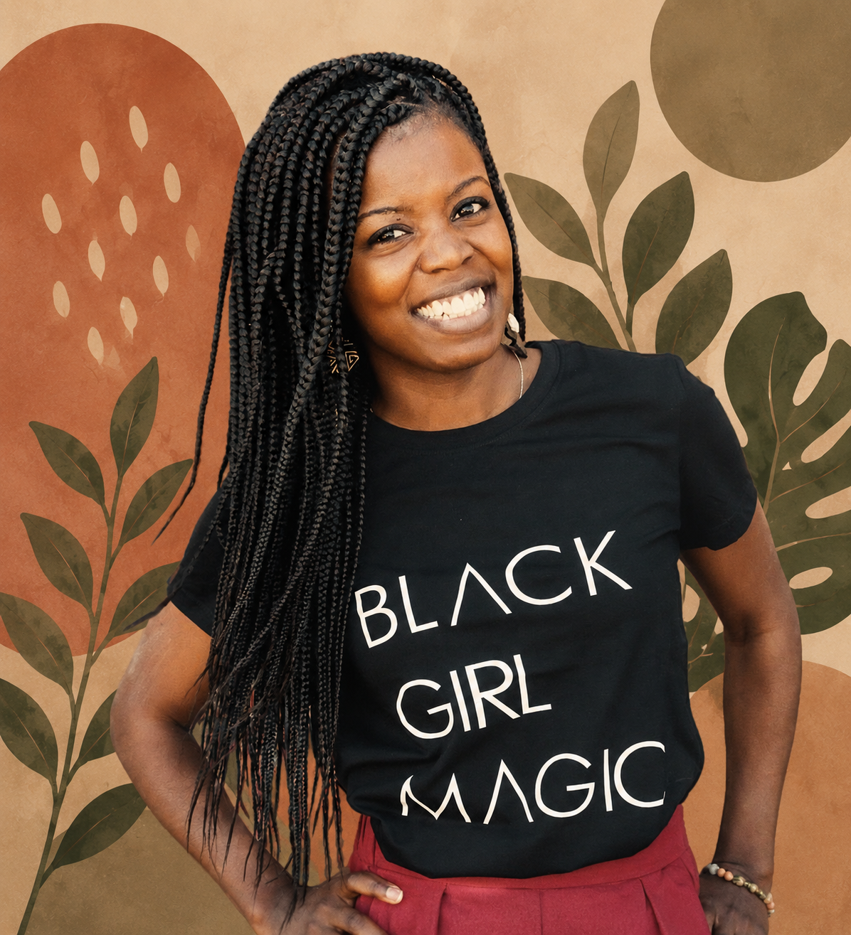 A smiling woman with long braided hair, wearing a black T-shirt with the words "Black Girl Magic" and red pants, standing in front of a colorful, abstract background with leaves and circles.
