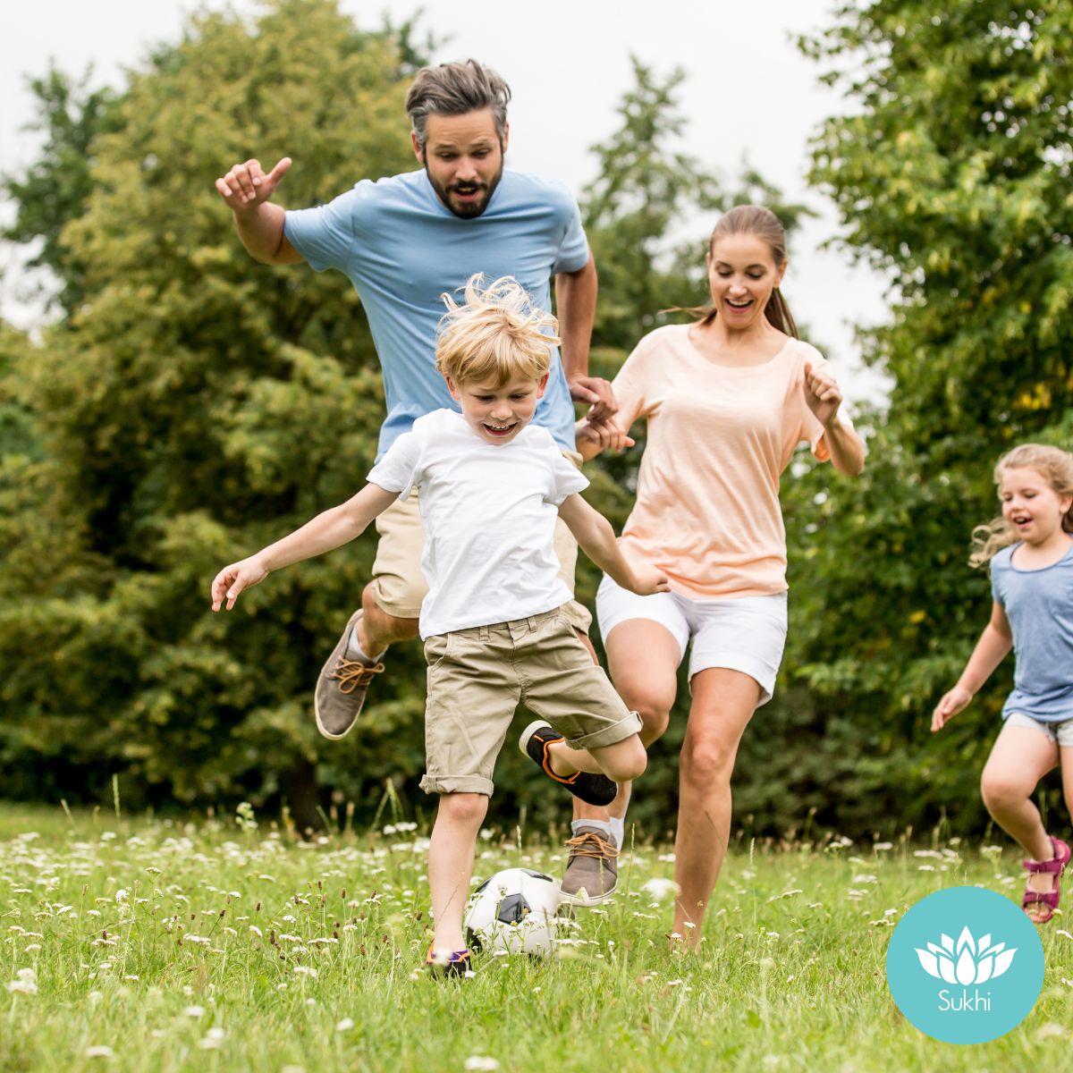 A happy family playing soccer during summertime