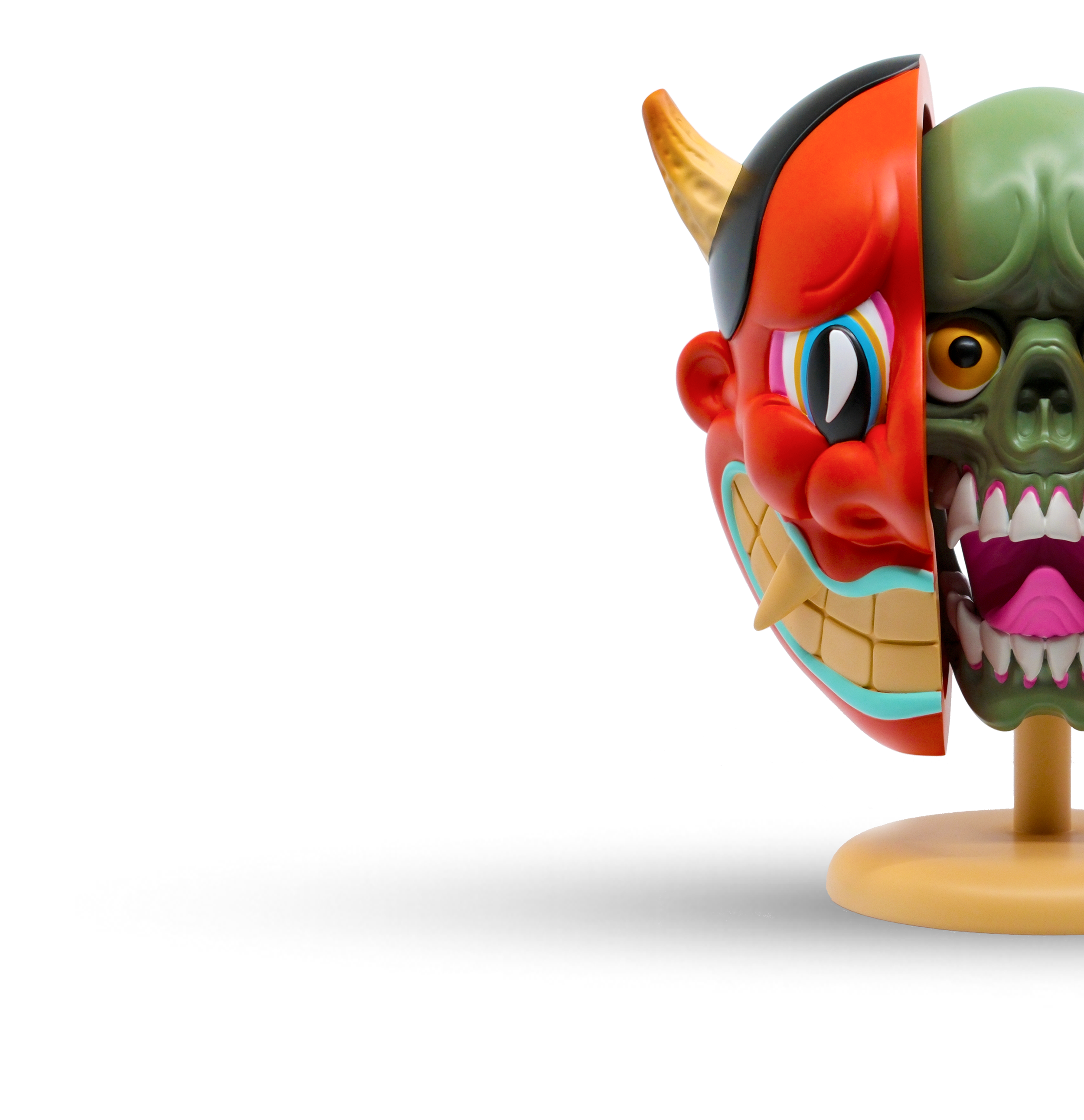 Colorful half-mask with one side resembling a demon and the other side resembling a skull, mounted on a wooden base against a white background.