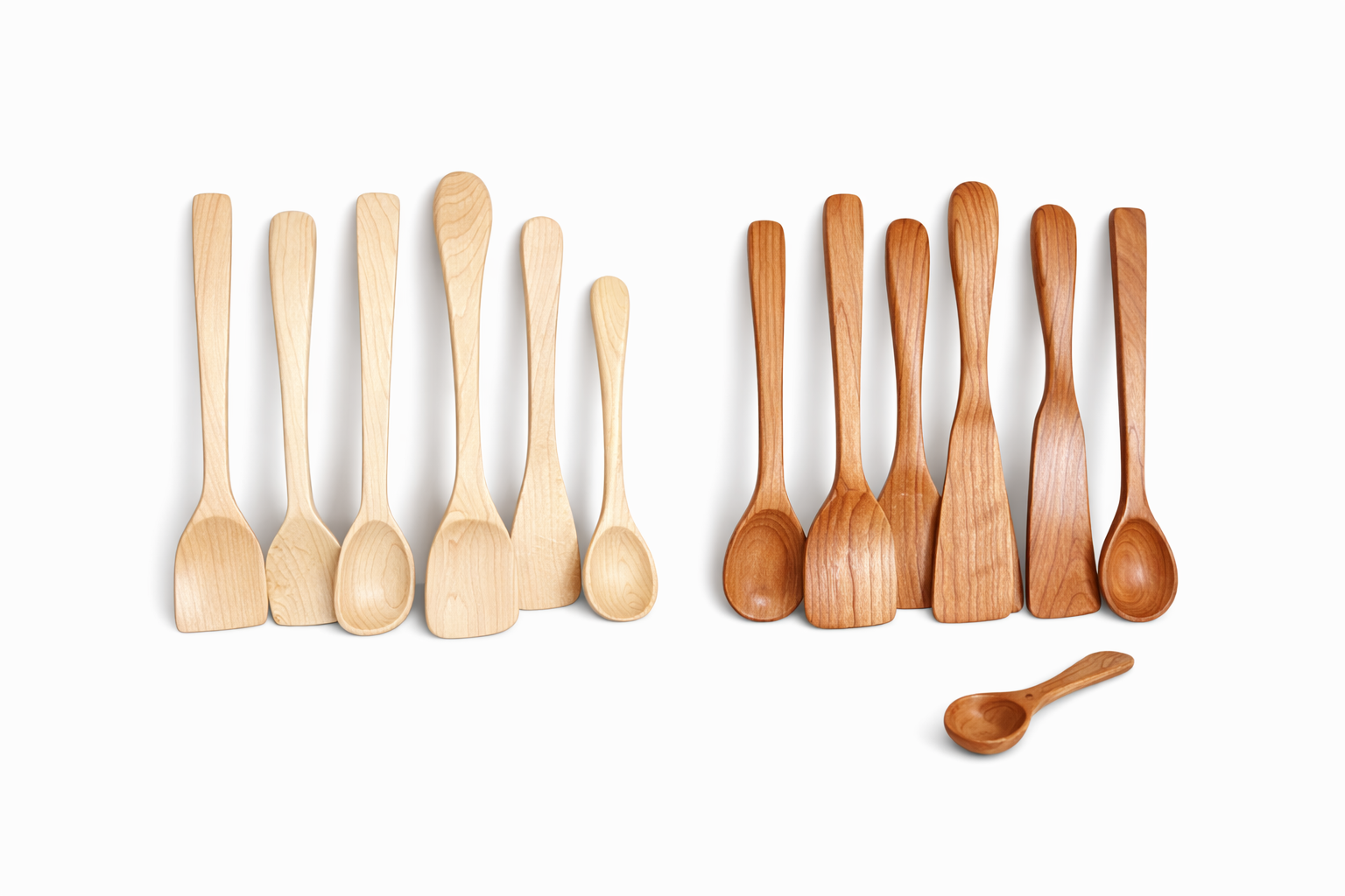Two sets of wooden spoons, one light-colored and one darker, arranged in a row on a white background with a single spoon placed at the bottom right.