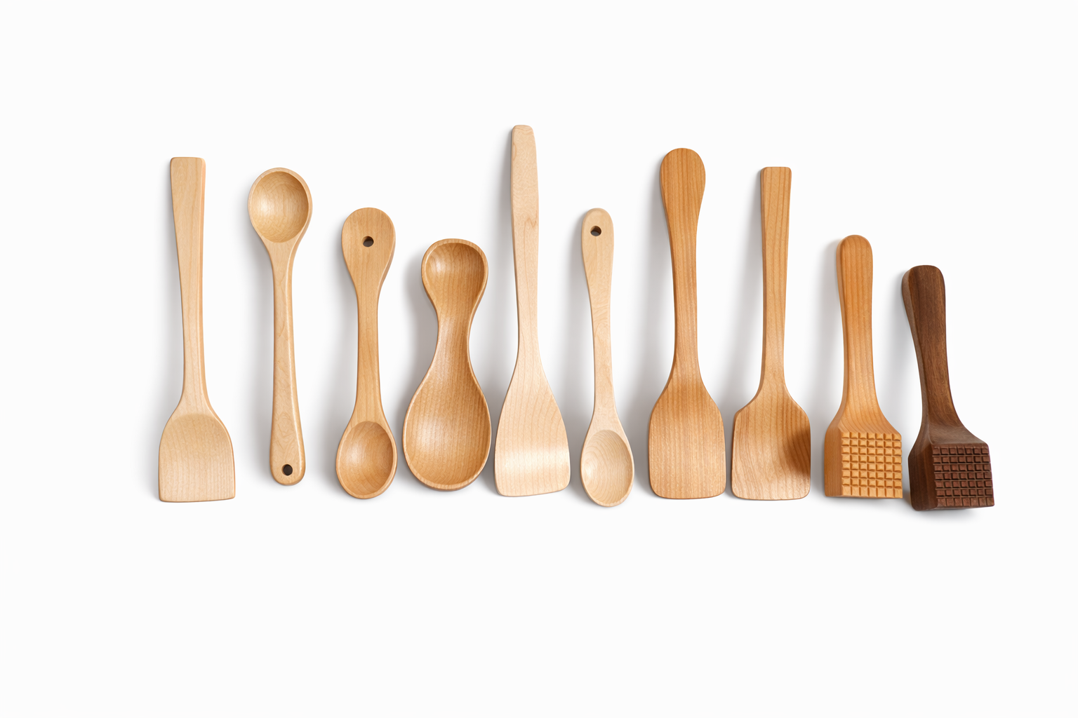 A row of ten wooden kitchen utensils on a white background, including spatulas and spoons in various shapes and wood tones.