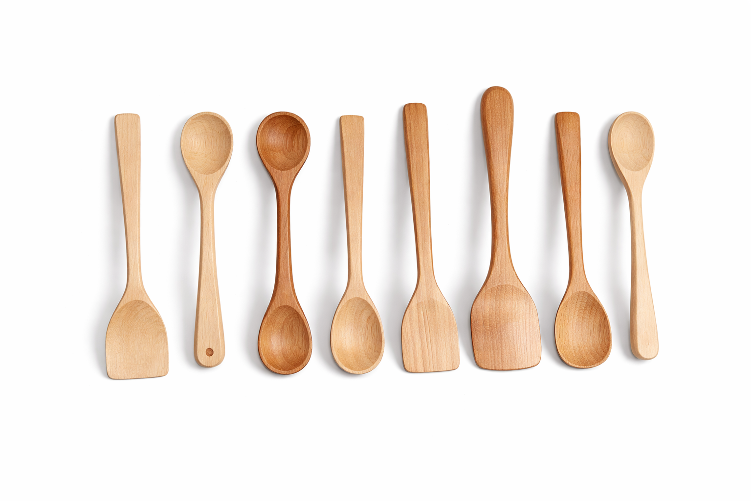 Eight wooden spatulas arranged in a row on a white background, varying in size and shape.