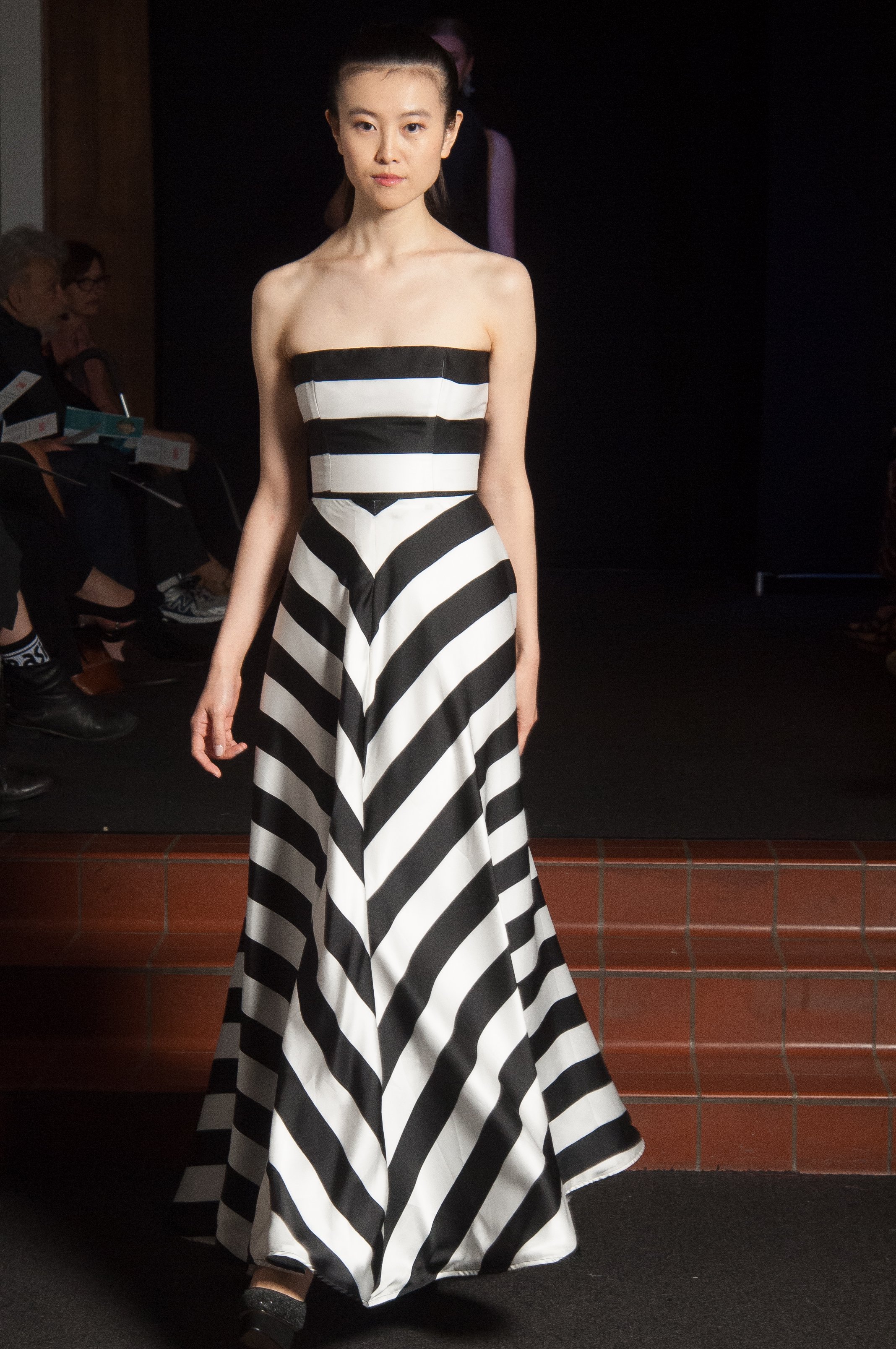 Model wearing strapless down that is black and white striped.
