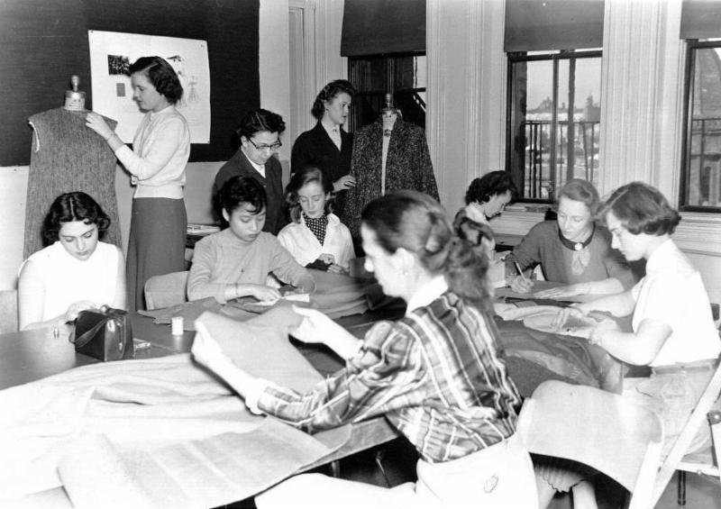 Students gathered around table sewing