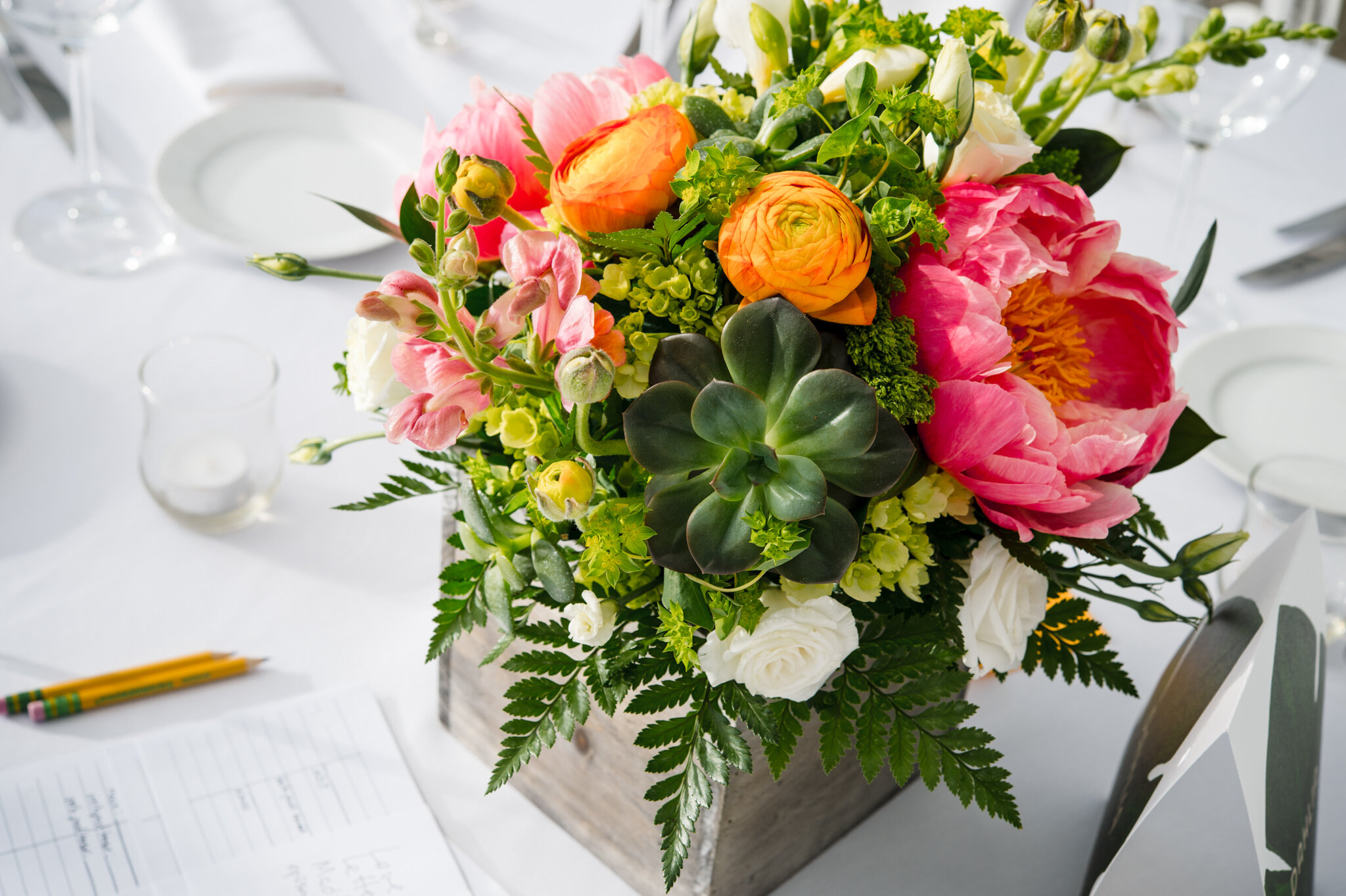 Bright floral centerpiece on guest reception table during queer wedding at Roger Williams Botanical Center Providence Rhode Island Michelle Schapiro New England Portrait Photographer