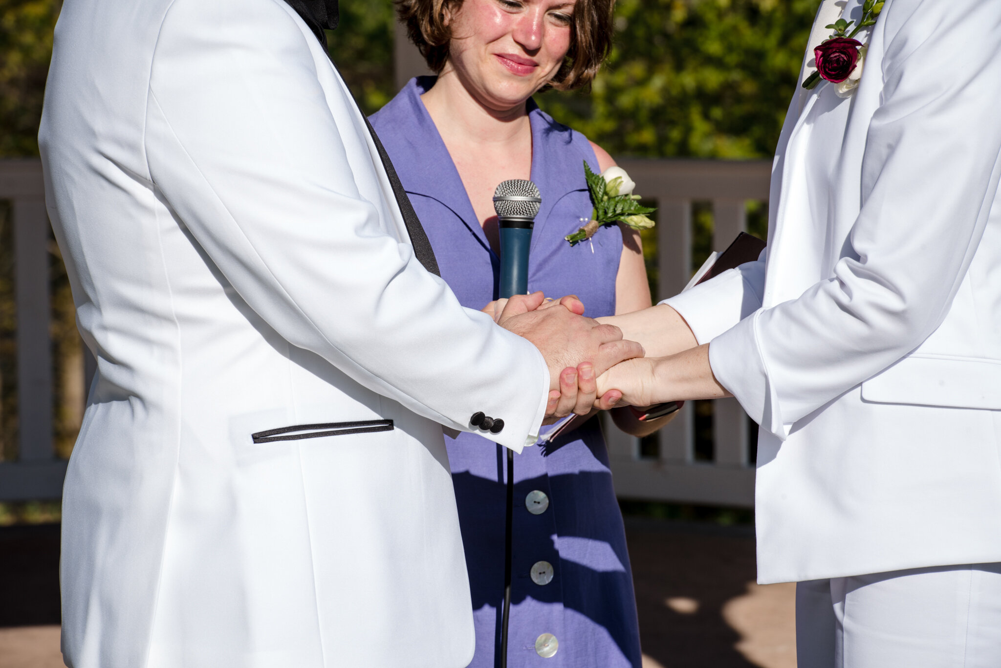 Marriers in white suits hold hands during ceremony at Roger Williams Botanical Center Providence Rhode Island Michelle Schapiro New England LGBTQ Photographer